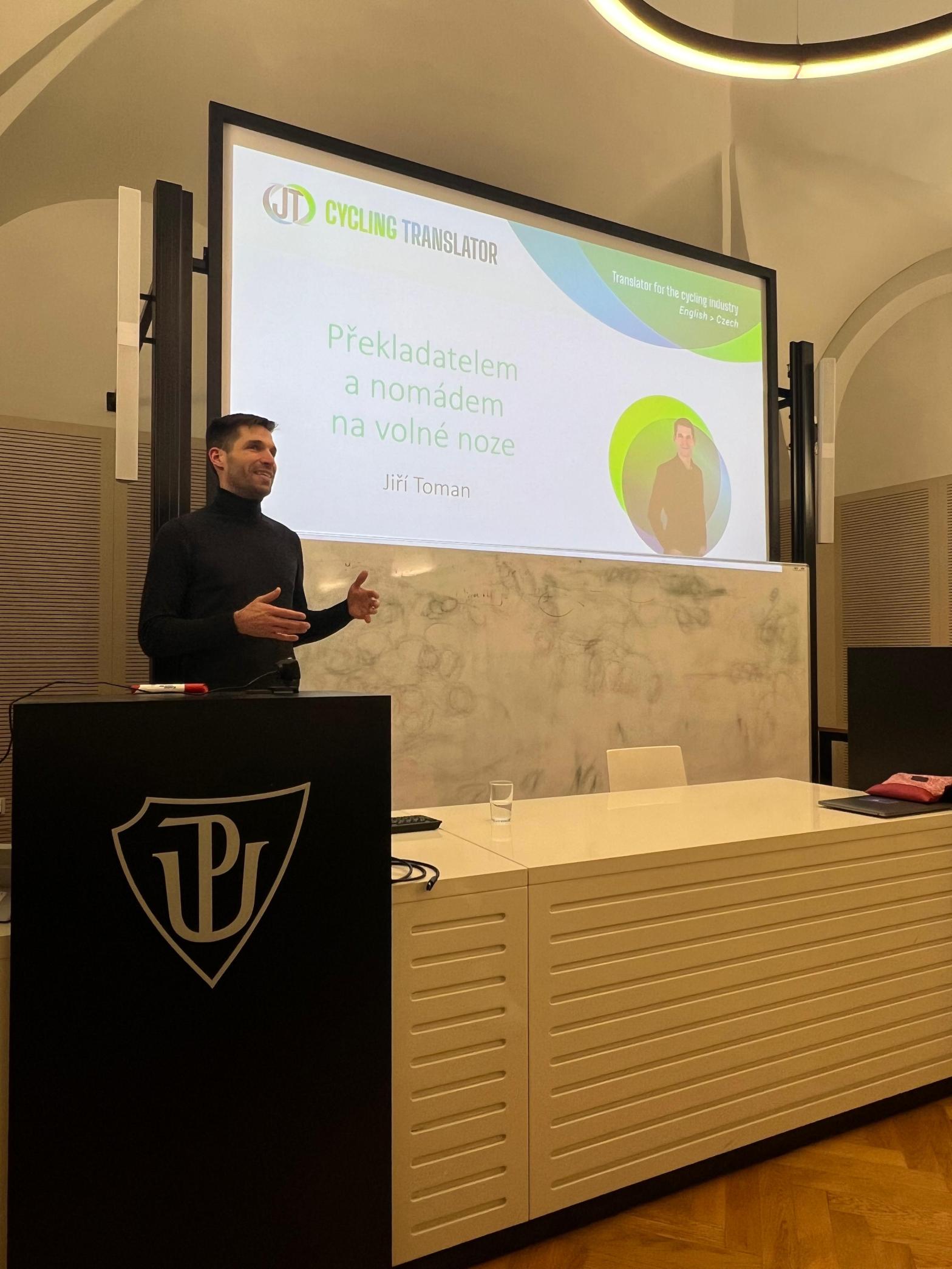 Jiri is stood in front of a university class delivering a lecture